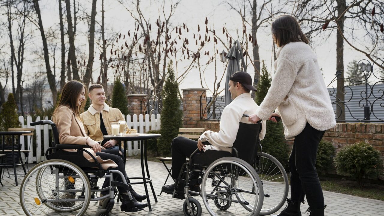 A group of people in wheelchairs sitting around a table together