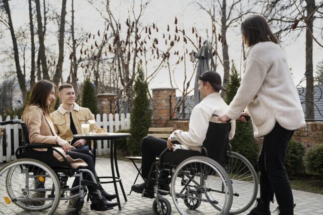 A group of people in wheelchairs sitting around a table together