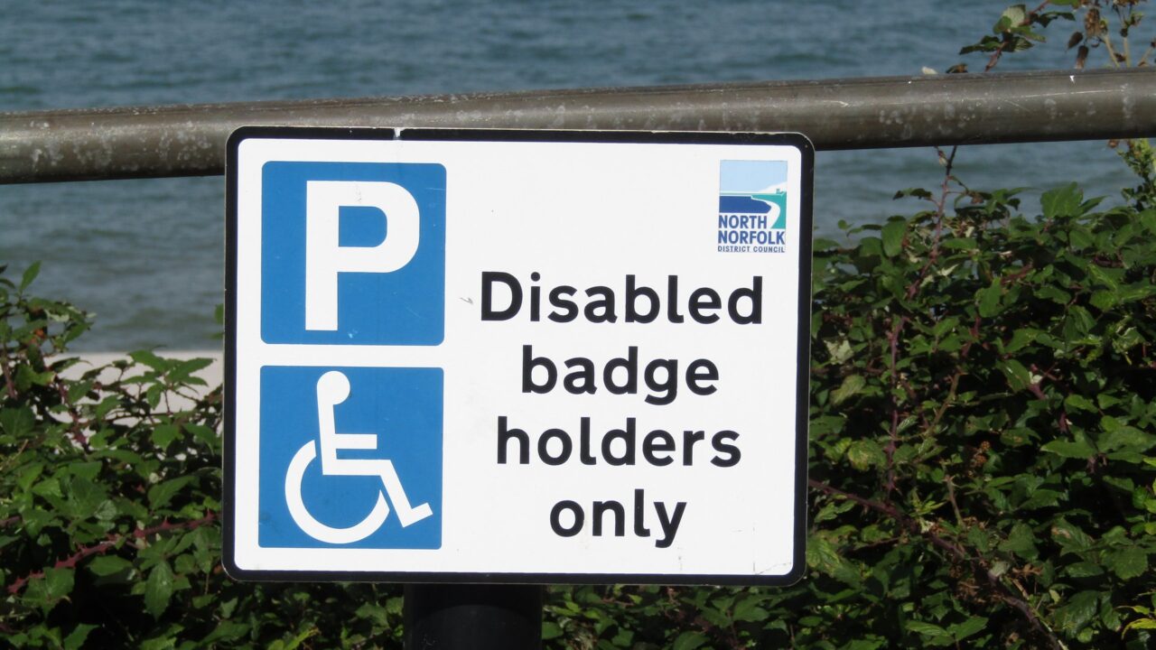 Blue disabled parking sign marking a designated bay in a UK car park