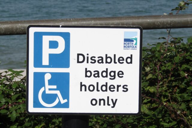 Blue disabled parking sign marking a designated bay in a UK car park