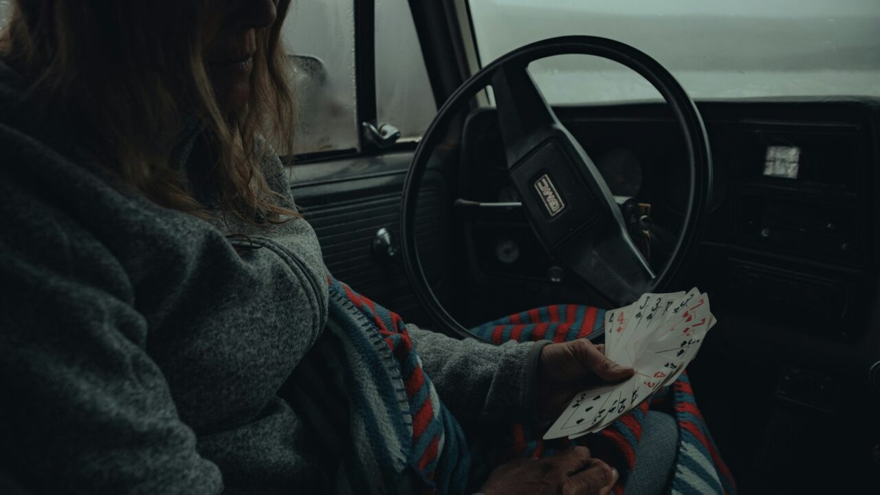 Woman sitting in a car holding a piece of paper