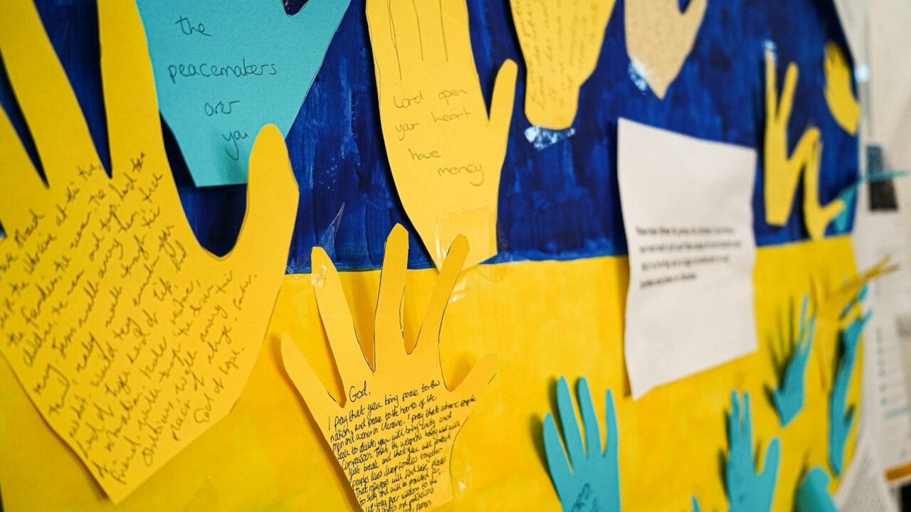 A bulletin board displaying handprints and writing