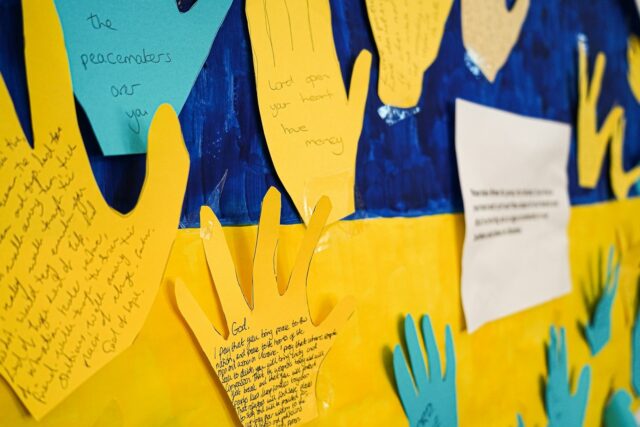 A bulletin board displaying handprints and writing