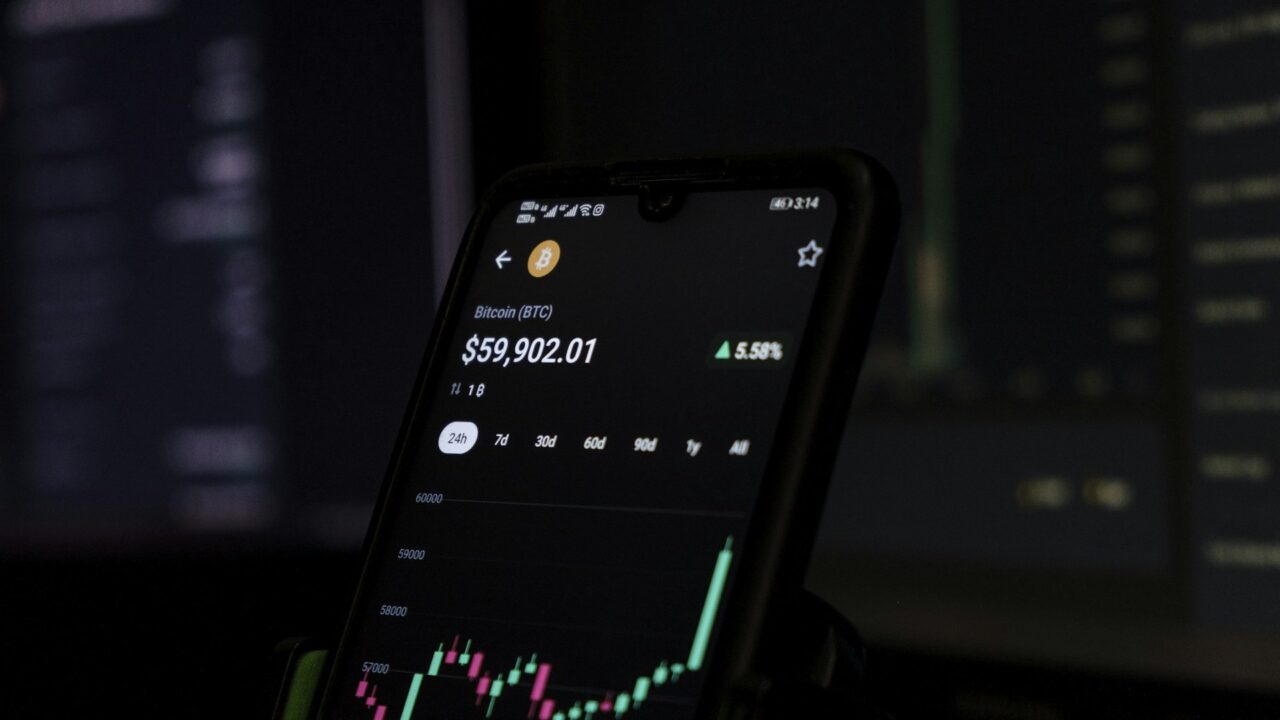 Mobile phone displaying a stock price chart with candlestick pattern and green upward trend line