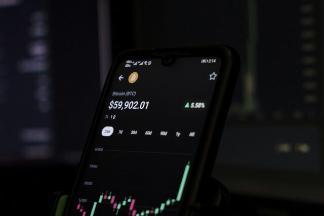 Mobile phone displaying a stock price chart with candlestick pattern and green upward trend line