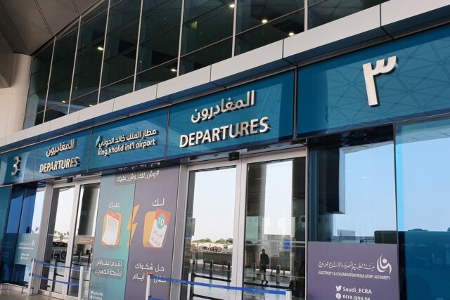 Interior view of airport departures area at Riyadh Airport with signage and passenger facilities