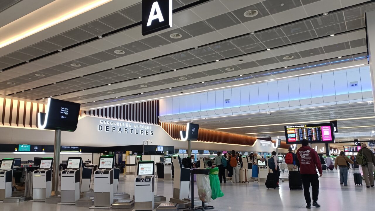 Departure hall at Manchester Airport Terminal 2, showing check-in desks and departure boards.