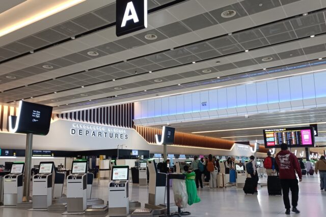 Departure hall at Manchester Airport Terminal 2, showing check-in desks and departure boards.