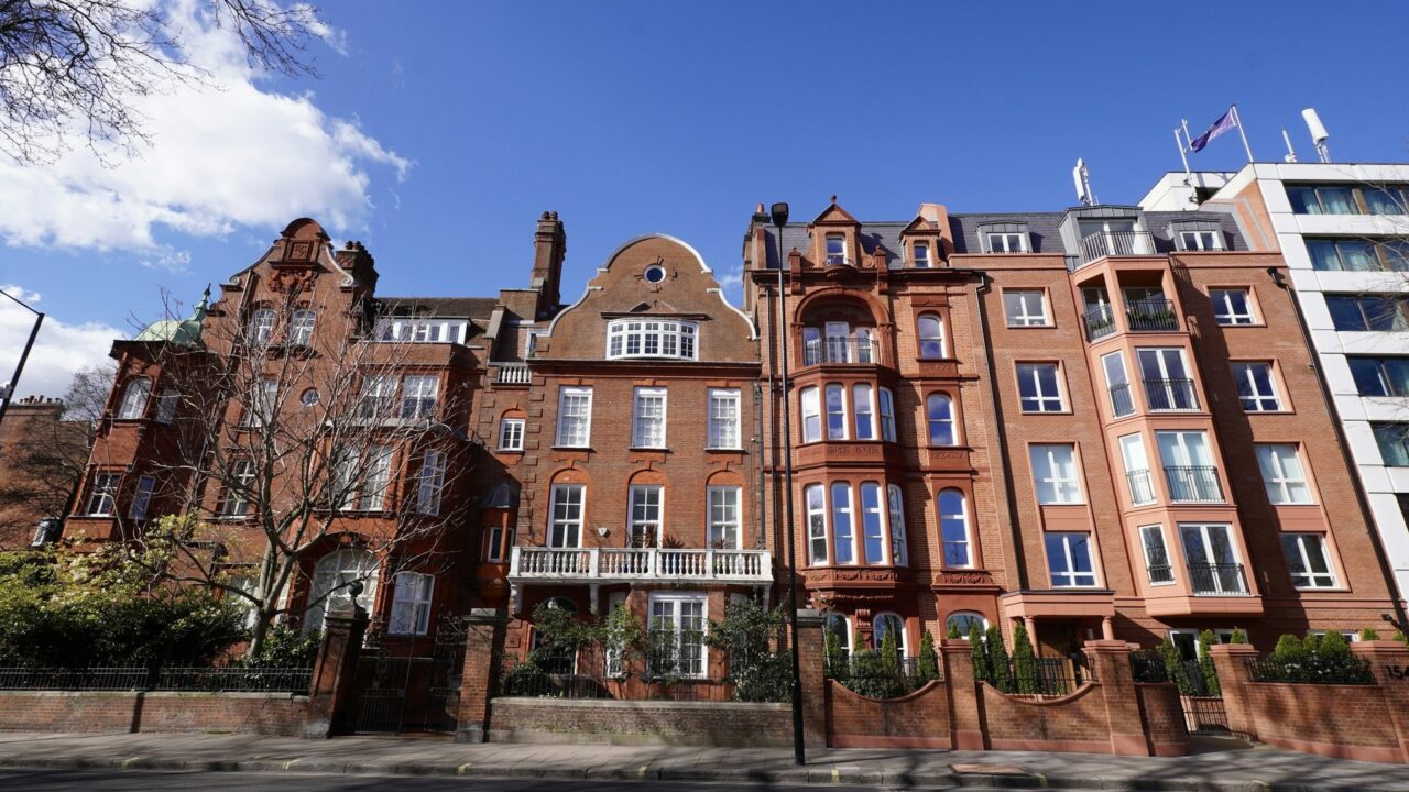 Row of red brick Victorian buildings on a city street in London