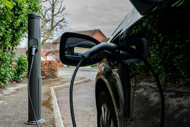 An electric car plugged into an outdoor charging station