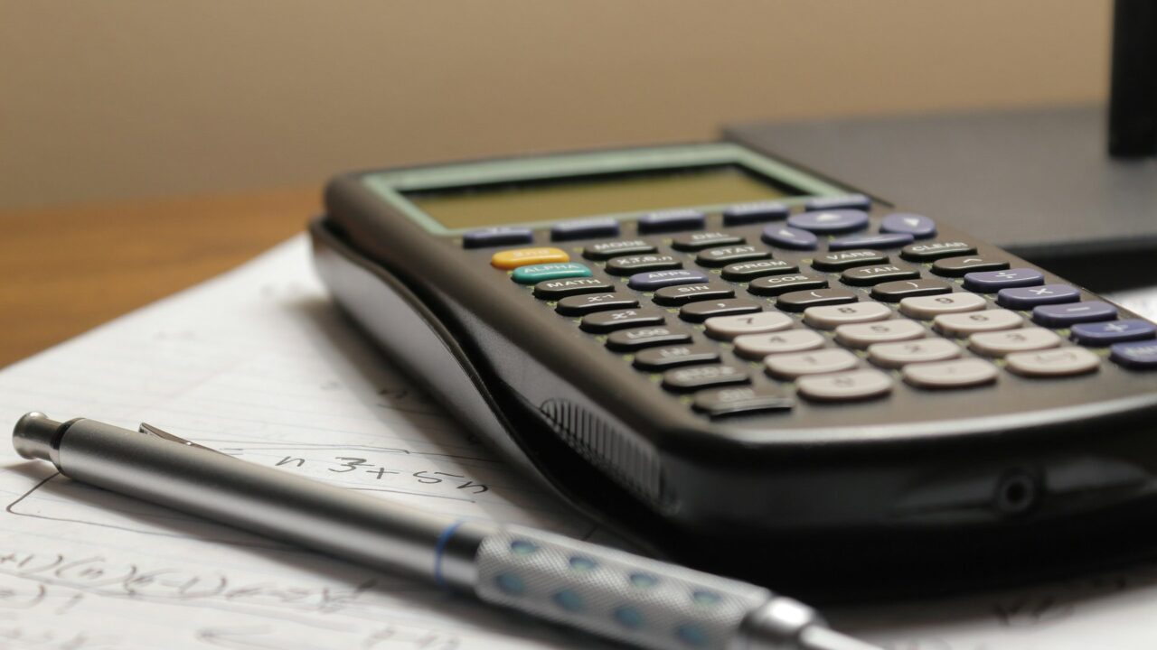 A calculator and pen on a document representing financial planning and tax calculations