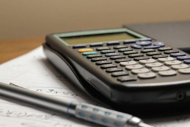 A calculator and pen on a document representing financial planning and tax calculations