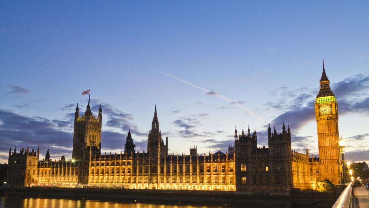 Big Ben and the Houses of Parliament illuminated at dusk, reflected in the River Thames