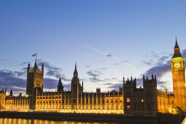 Big Ben and the Houses of Parliament illuminated at dusk, reflected in the River Thames