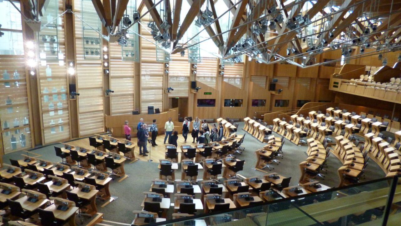 Interior of the Scottish Parliament debating chamber at Holyrood with tiered seating and parliament in session