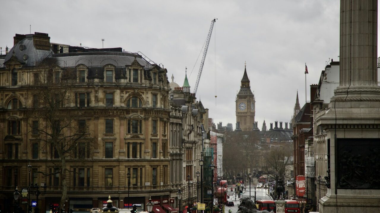 A busy London street scene with Big Ben and Houses of Parliament visible in the background