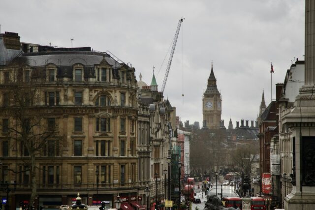 A busy London street scene with Big Ben and Houses of Parliament visible in the background