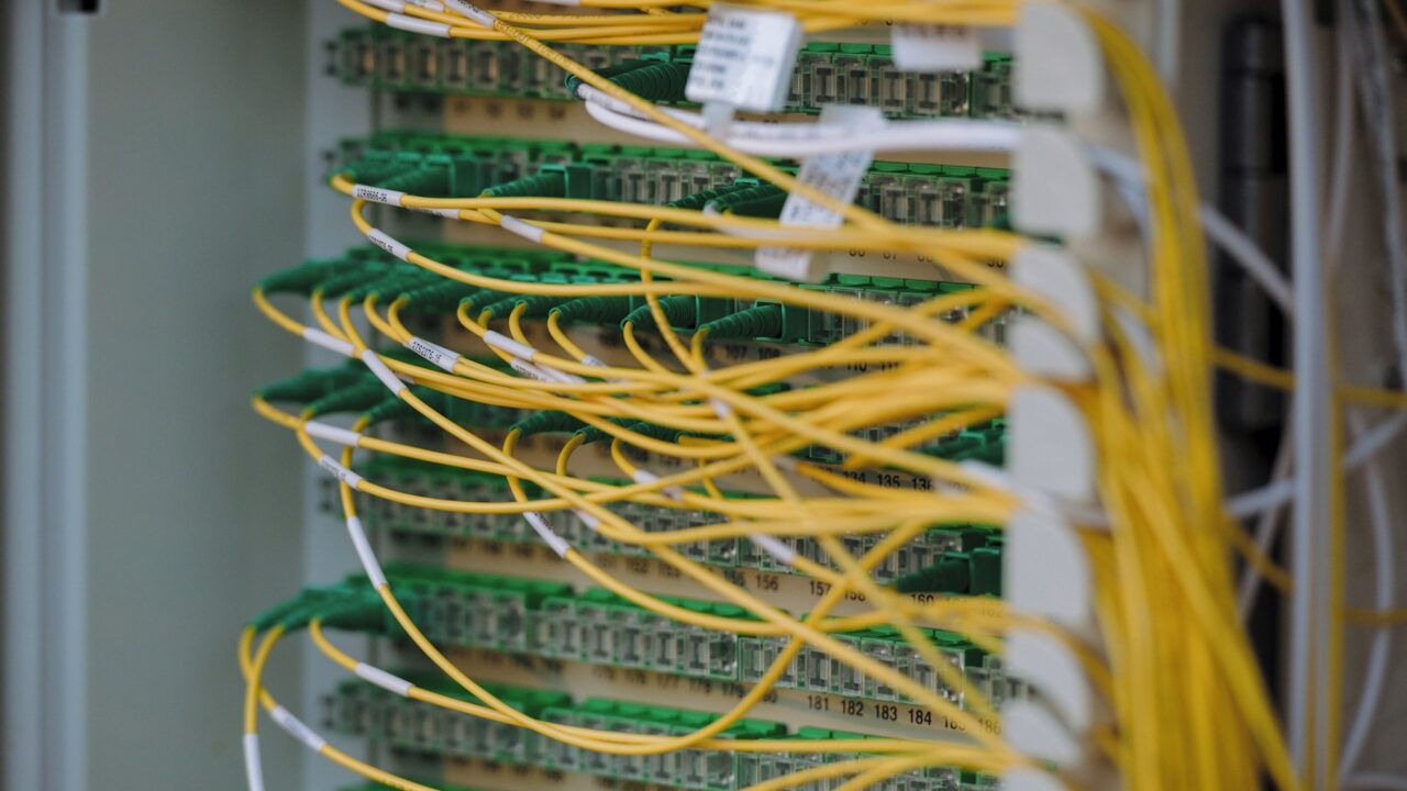 Yellow and green network cables neatly organized and connected to server equipment in a data center rack.