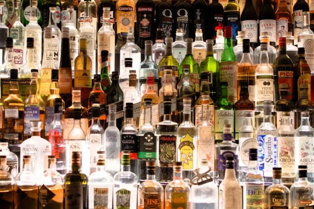 Multiple bottles of assorted spirits, wines, and liqueurs displayed together on shelves