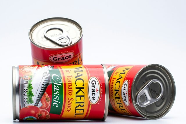 Two red tins of canned food stacked together against a white background