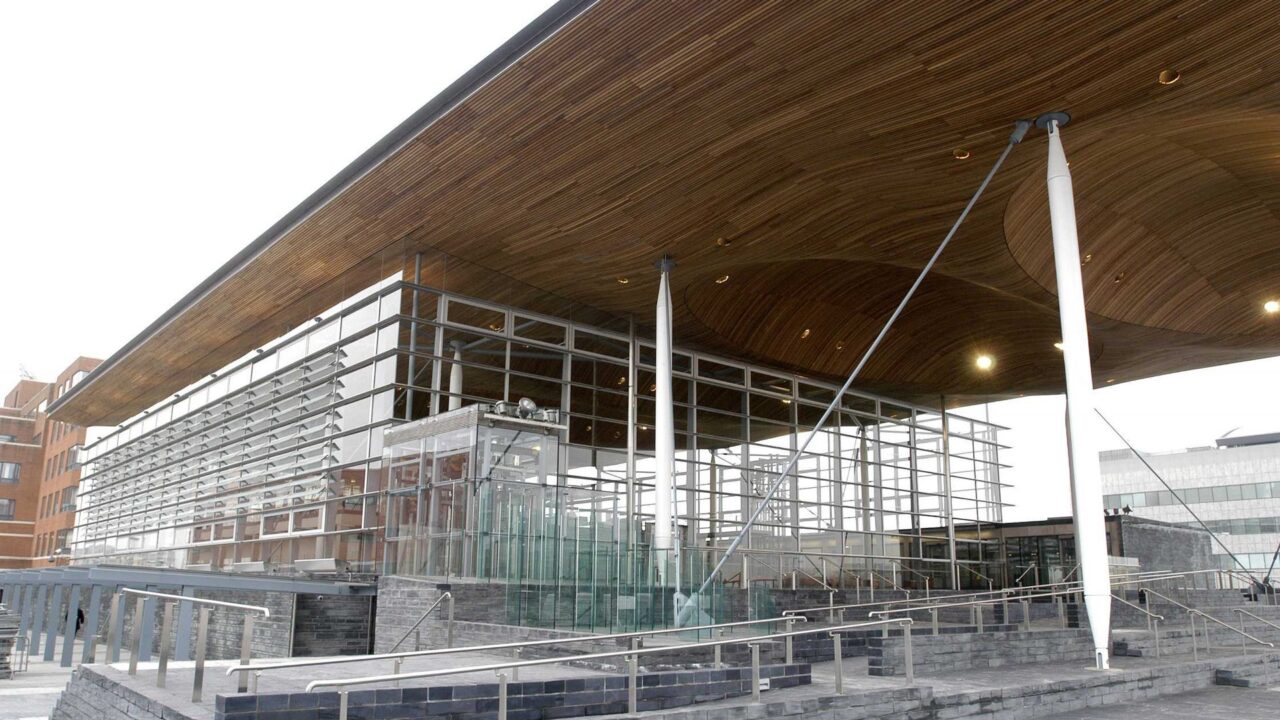 The Senedd building in Cardiff Bay, Wales, a modern curved structure on the waterfront.