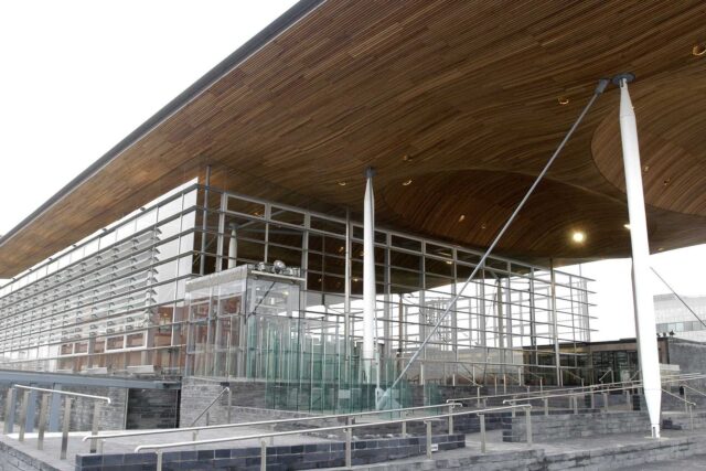 The Senedd building in Cardiff Bay, Wales, a modern curved structure on the waterfront.